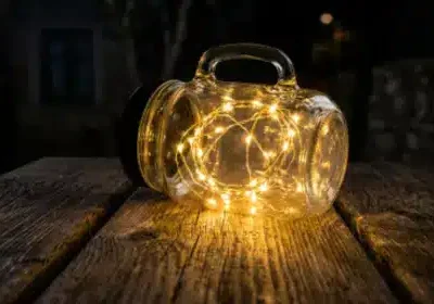 Ein brauner Tisch, auf dem eine umgefallene, noch leuchtende Solarlampe liegt
